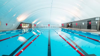 Leeres Hallenschwimmbad mit Bahnen.