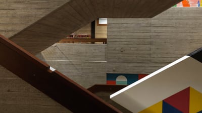 Moderne Treppe mit geometrischen Formen und Betonwänden.