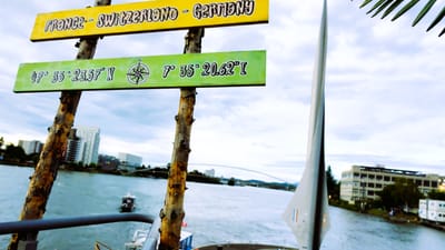 Doppelte Belichtung von Kunstinstallation und Stadtlandschaft am Flussufer.