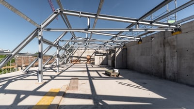 Metallrahmenbau auf Baustelle unter blauem Himmel.