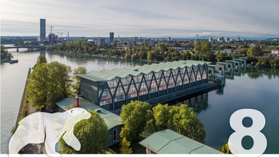 Luftaufnahme Rhein beim Kraftwerk, Gebäude und Bäumen, mit weissem Bären und Zahl 8.