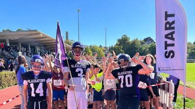 Amerikanische Football-Spieler bei einem Sportereignis neben einem Startbereich.