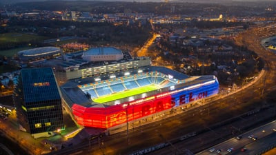 A bird's eye view of the FCB stadium illuminated in red and blue. 