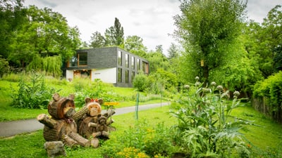 Modernes Haus inmitten eines grünen Gartens mit Holzschnitzereien von Bären.