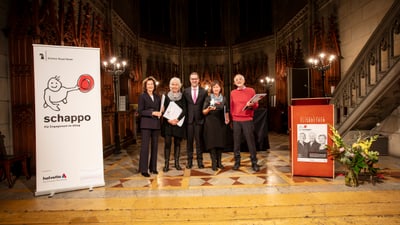 Die Abgabenstellenleitenden posieren mit schappo Preis und Zertifikaten zusammen mit Regierungspräsident Dr. Conradin Cramer.