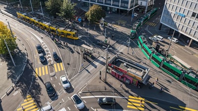 Strassenbahn und Fahrzeuge an einer belebten Kreuzung.