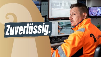 Mann in orangefarbener Jacke vor Computerbildschirmen, Text 'Zuverlässig.'