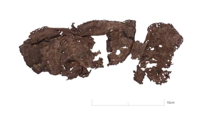 Archäologisches Schuhfragment aus braunem Leder, 10 cm Massstab.