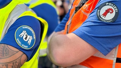 Polizisten in gelben und orangefarbenen Westen mit Abzeichen Basel-Stadt und Basel-Landschaft.