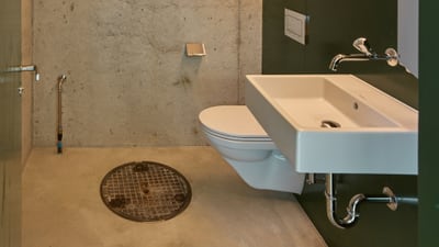 Kleiner moderner Raum mit WC, Waschbecken und einem Spiegel.