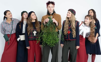 Gruppe junger Menschen in stilvoller Kleidung mit Pflanzen.