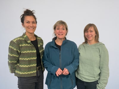 Rauati Erni, Claudia Dürr, Salome Wyss lächelnd vor einem neutralen Hintergrund.