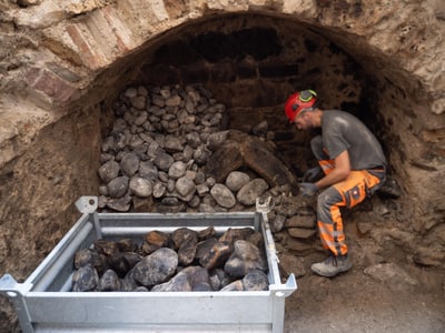 Eine Person in einer Höhle bewegt Steine.