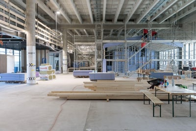 Baustelle im Innenbereich mit Baugerüsten und Materialien.
