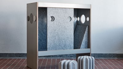 Designer-Raumteiler mit Ausschnitten und Würfelhockern auf Fliesenboden.