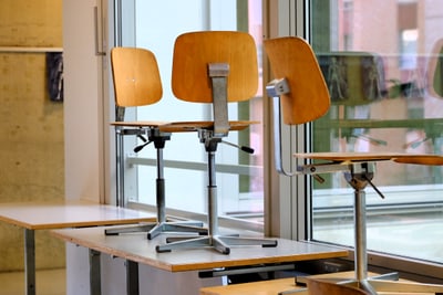 Hochgestellte Stühle auf Tischen.