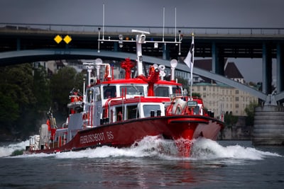 Feuerlöschboot auf dem Fluss vor Brücke in Basel.",