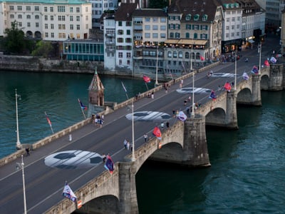 Historische Brücke über Wasser mit Flaggen und Fussgängern.