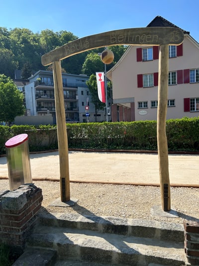 Holzbogen mit Kugel und Haus im Hintergrund in Bettingen.