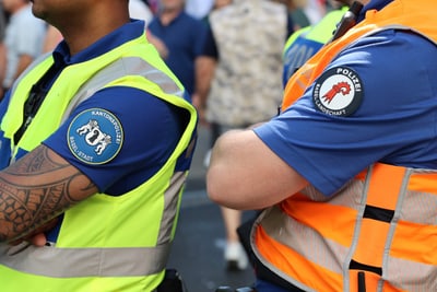Polizisten in gelben und orangefarbenen Westen bei einer Veranstaltung.