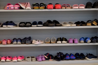 Mehrere Reihen von bunten Schuhen auf Regalen.