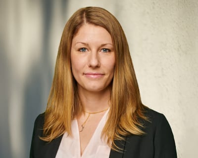 Porträt einer Frau mit langen Haaren im Anzug.