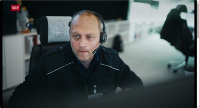 Mann mit Headset sitzt konzentriert vor einem Bildschirm in der Rettungszentrale.