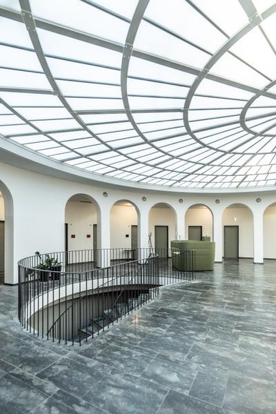 Moderner grosser Raum mit Glasdach und Wendeltreppe.
