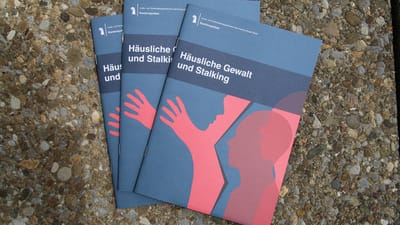 Broschüren über häusliche Gewalt und Stalking auf Schotterboden.