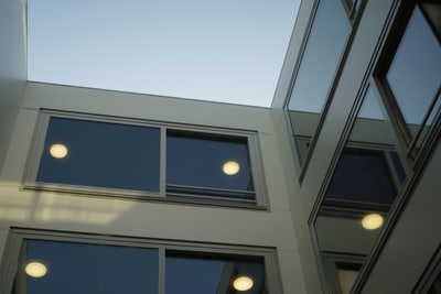 Blick nach oben auf modernes Gebäude mit Glasfenstern.