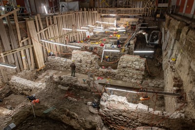 Archäologische Ausgrabungsstätte mit Bauarbeiten und Beleuchtung.