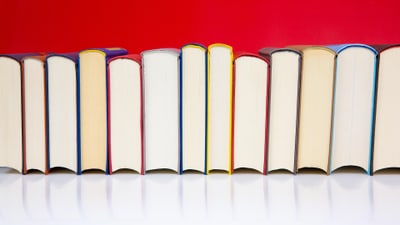 Reihe von Büchern vor rotem Hintergrund.