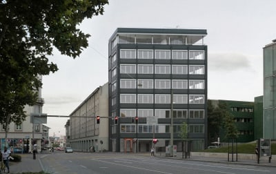 Strassenszene mit modernem Gebäude und Bäumen bei einer Kreuzung.