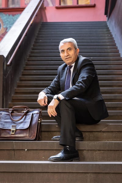 Mustafa Atici auf Treppe mit Aktentasche.
