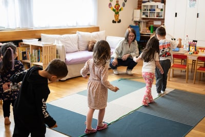 Kinder spielen auf dem Boden in der Spielgruppe.