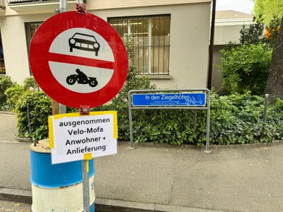 Verbotsschild für Autos und Motorräder mit Ausnahmehinweis an Strasse 'In den Ziegelhöfen'.
