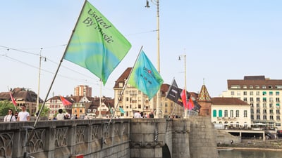 Brücke in Basel mit wehenden bunten Fahnen im Wind.