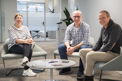 Nicole Thoma, Cristoforo Graziano und Markus Gsell sitzen in einem Büro auf Sesseln um einen Tisch herum.