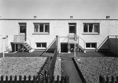 Reihenhäuser mit Garten und Treppe in Schwarzweissfotografie.