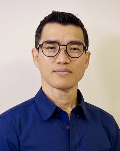 Youwaraj Rai, neuer Mitarbeiter bei der Materialzentrale - Mann mit Brille, kurzen schwarzen Haaren und blauem Hemd.