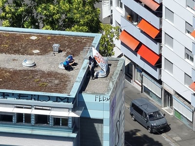 Eine Person auf einem flachen Dach in einer Stadtumgebung.