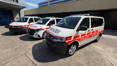 Drei Polizeiautos parken nebeneinander auf einem Parkplatz.