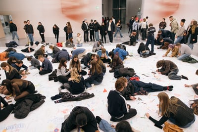 Menschen zeichnen auf grossem Papier im Kunstmuseum Basel.